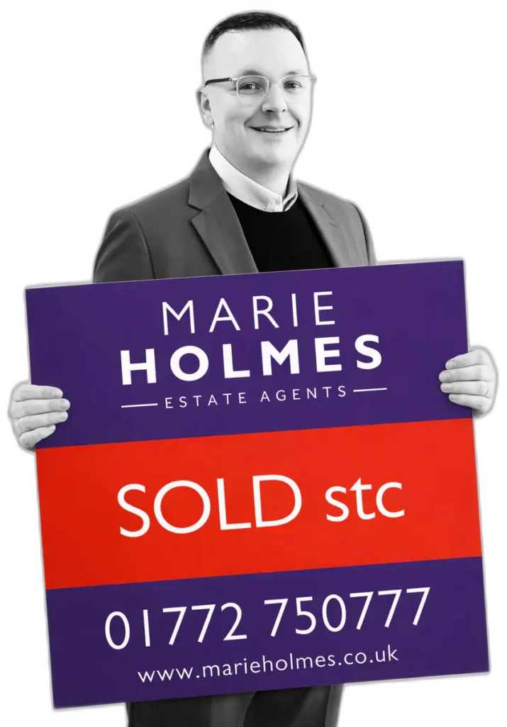 Chris of Marie Holmes Estate Agents holding a Sold STC board